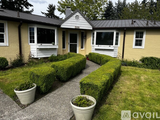 A house with a front yard and a hedge.