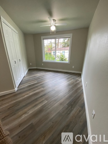 A room with wooden flooring and a window.