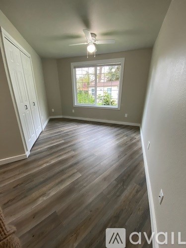 A room with wooden flooring and a window.