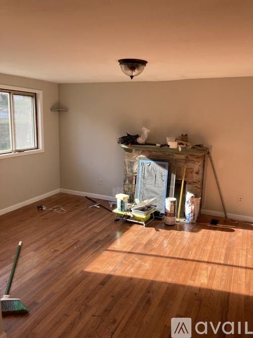 A room with wooden floors and a painting in progress.
