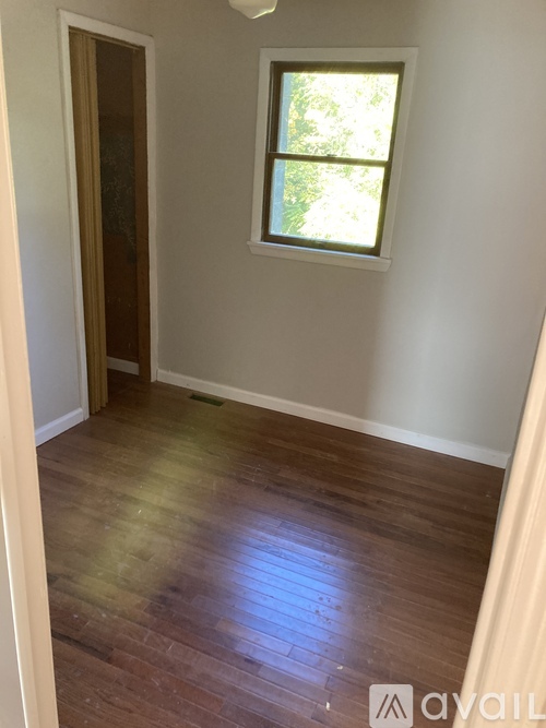 A room with wooden flooring and a window.