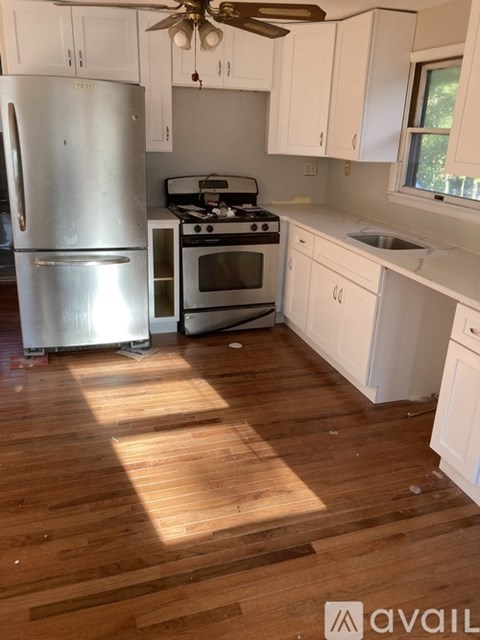 A kitchen with a refrigerator, oven, and stove.