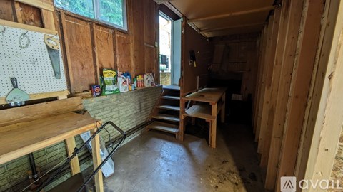 A kitchen with wooden walls and a wooden table with chairs.
