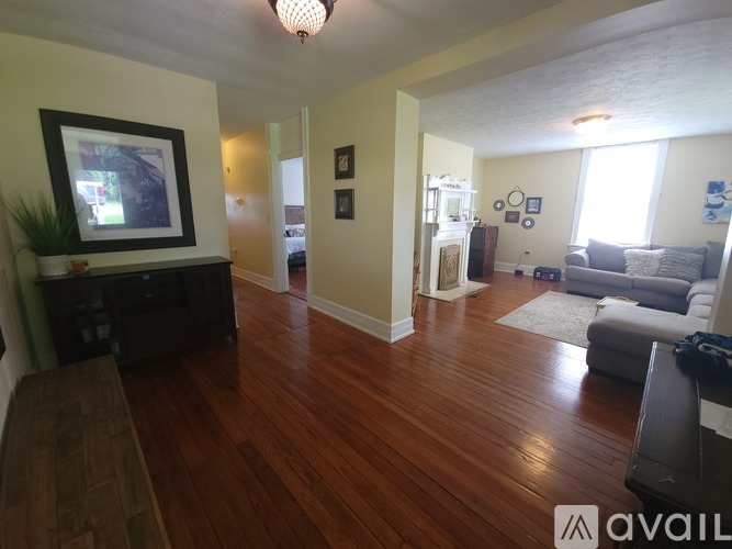 A living room with wood floors and a television.