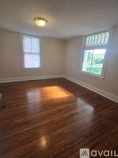A kitchen with wooden floors and a white refrigerator.
