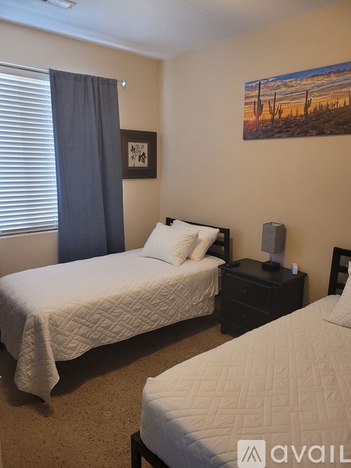 A bedroom with a large bed and a painting on the wall.
