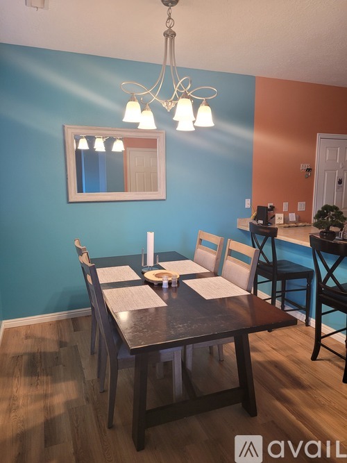 A dining room with a wooden table and chairs.