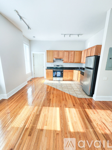 A kitchen with wooden floors and white walls.