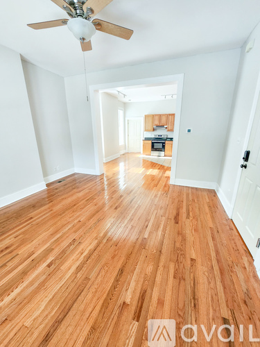 A room with wooden flooring and a ceiling fan.
