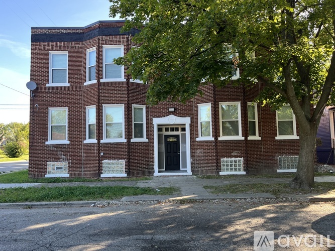A red brick building with a black door and windows.