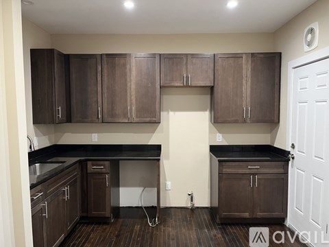 A kitchen with brown cabinets and black countertops.