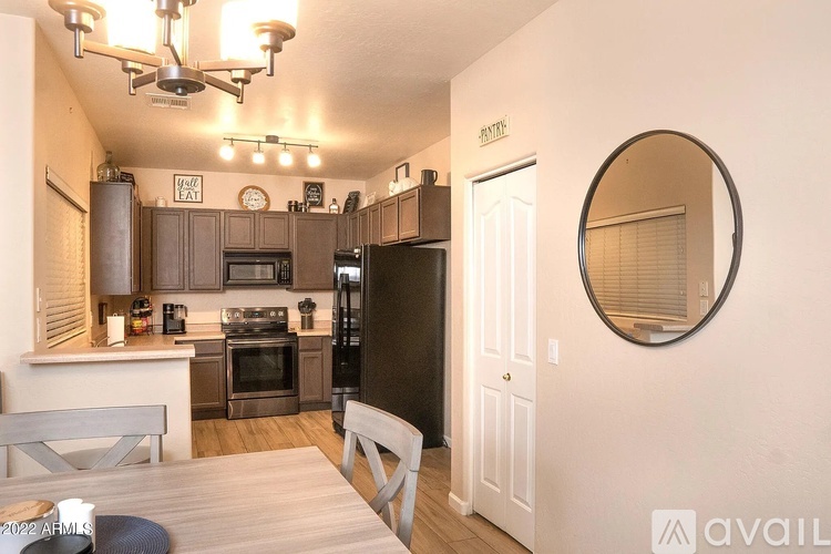 A kitchen with a dining table and chairs in front of it.