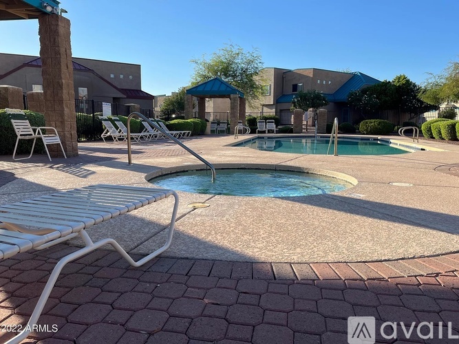 A pool area with a small pool and sun loungers.
