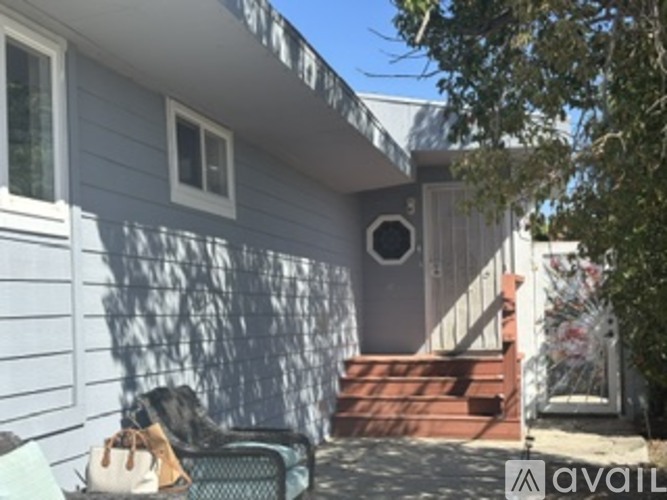 A grey house with a white garage door and a window with an air conditioner unit.