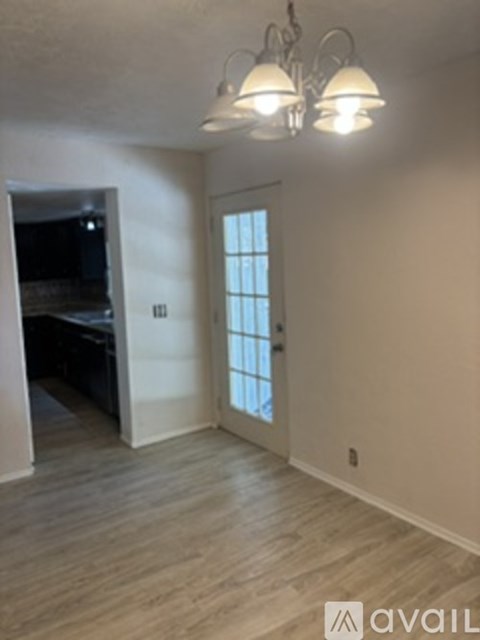 A kitchen with wooden floors and a white wall.