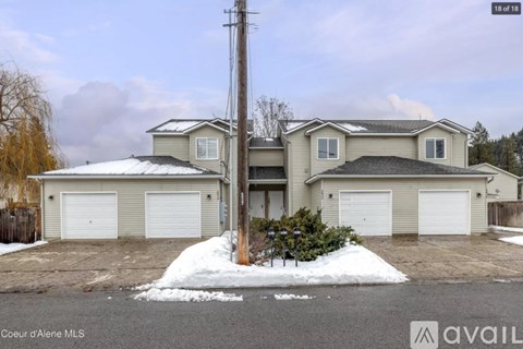 A house with a snow-covered ground in front of it.