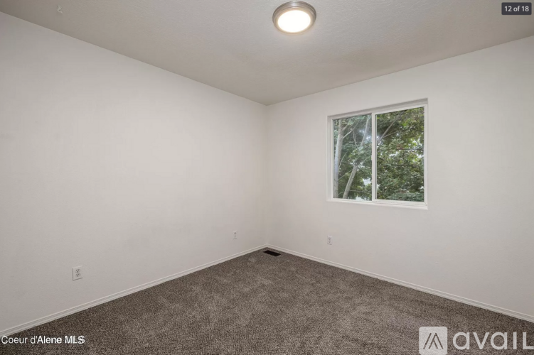 A room with a window showing trees outside.