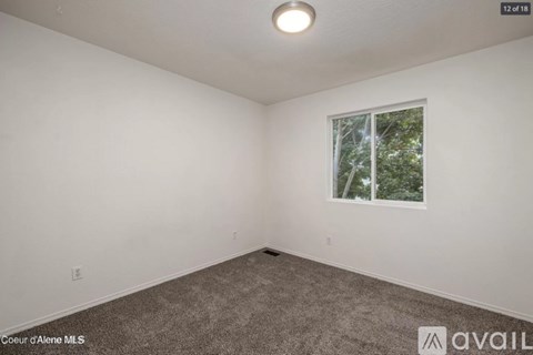 A room with a window showing trees outside.