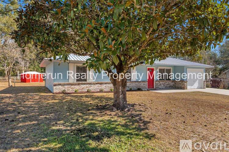 A tree stands in front of a building with the text "Home Run Realty Property Management" on it.