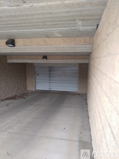 A concrete garage with a closed white door.