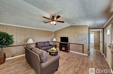 A living room with a brown couch and a ceiling fan.
