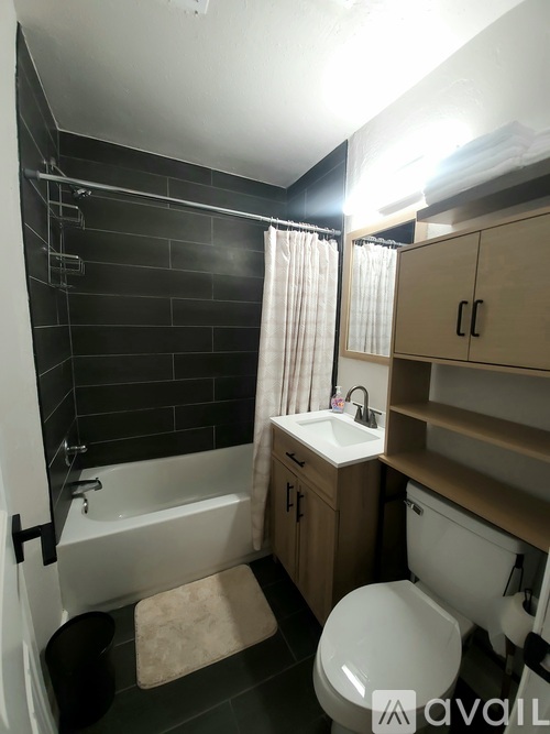 A bathroom with a white toilet, sink, and bathtub.
