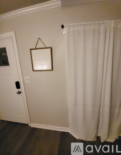 A white door with a black handle and a mirror above it.