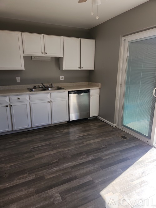 A kitchen with white cabinets and a stainless steel dishwasher.