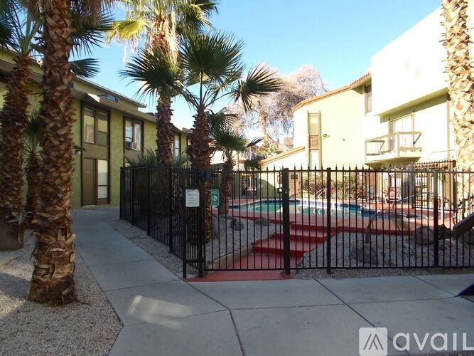 A gated community with a pool and palm trees.