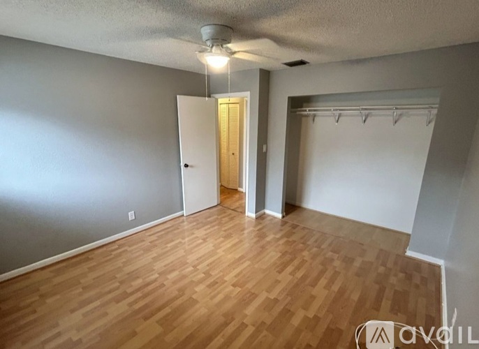 A room with wooden flooring and a ceiling fan.