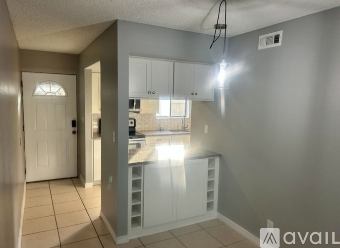 A kitchen with white cabinets and a countertop.