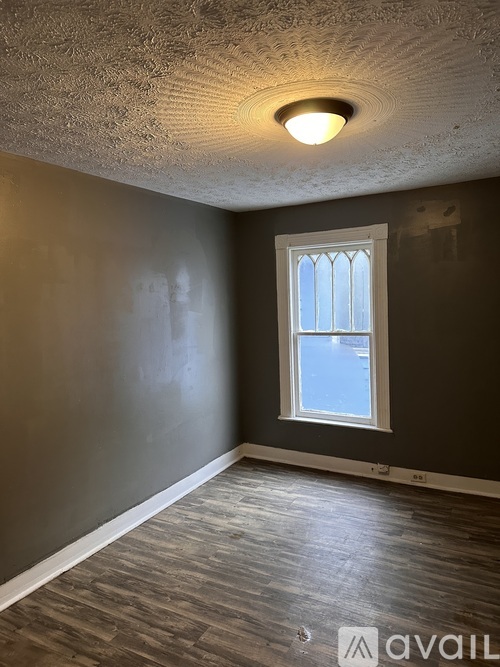 A room with a window and wooden flooring.