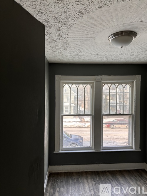 A room with a window showing a street view.