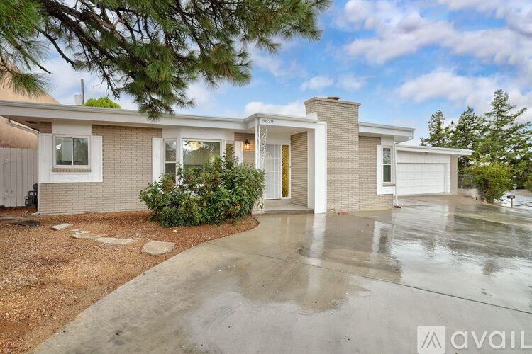 A house with a driveway and a tree in front.