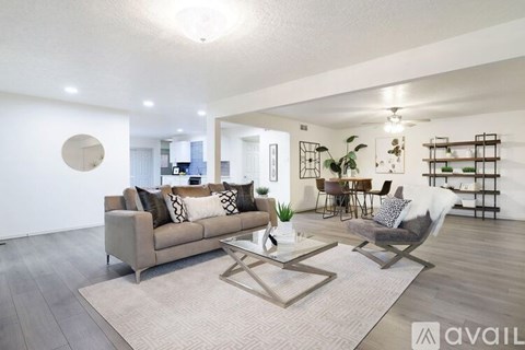 A modern living room with a grey sofa and a glass coffee table.