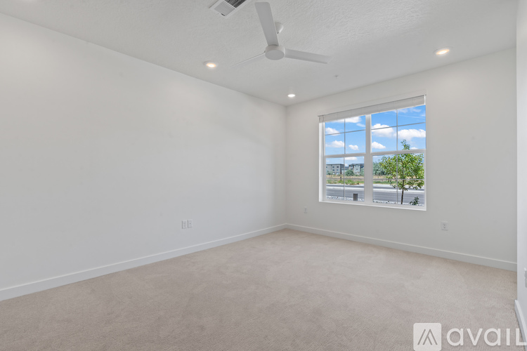A spacious room with a window overlooking a street.