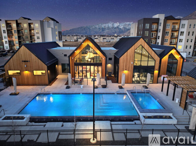A modern building with a pool in the foreground and snow-capped mountains in the background.