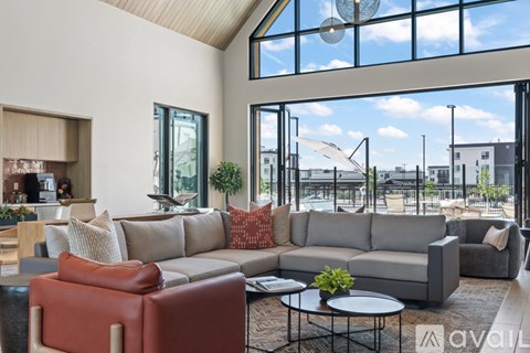 A living room with a large grey sofa and a red leather chair.