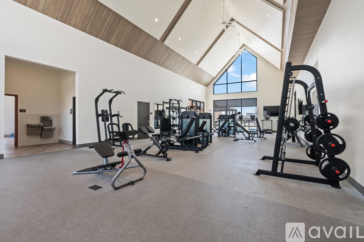 A gym with a variety of equipment including treadmills, weights, and exercise machines.