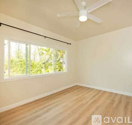 A room with a ceiling fan and a window with blinds.