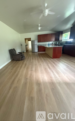 A room with wooden flooring and a ceiling fan.
