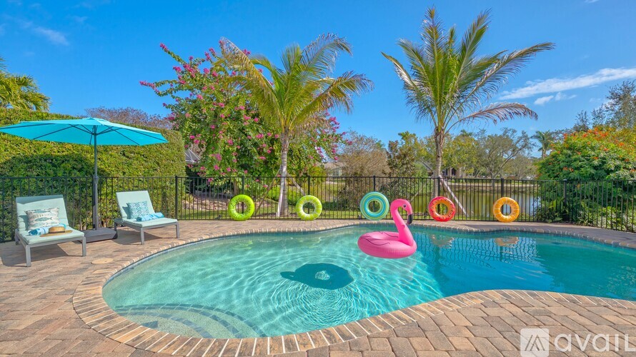 A pool with a pink flamingo float in the middle of it.
