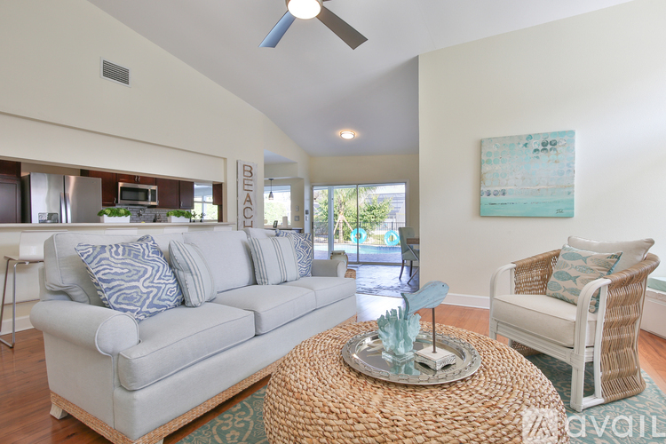 A living room with a grey couch and a wicker table.