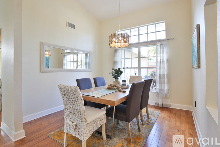 A dining room with a table and chairs.