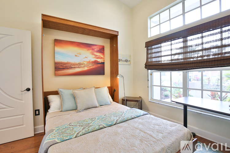 A bedroom with a large bed and a painting on the wall.