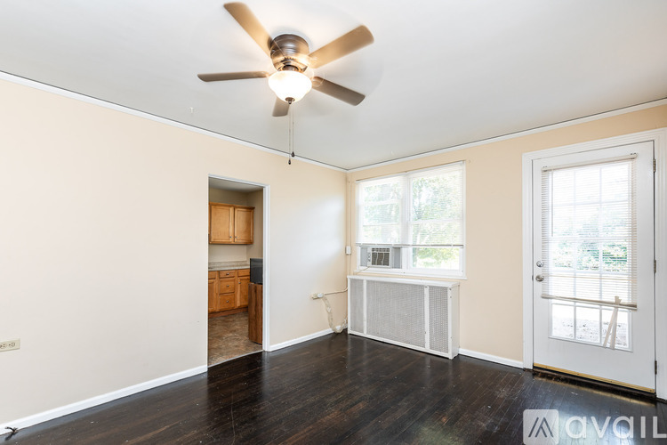 A room with a ceiling fan and a window with blinds.