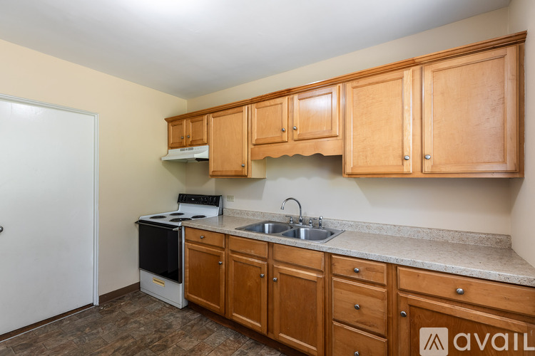 A kitchen with wooden cabinets and a white fridge.