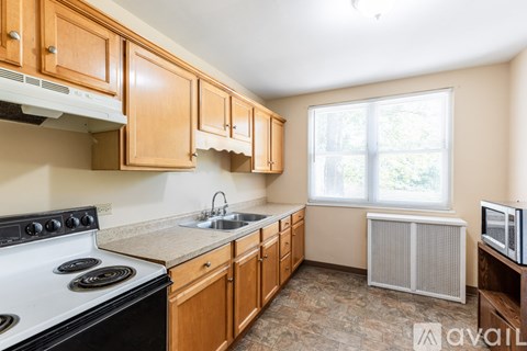 A kitchen with wooden cabinets and a white stove top oven.