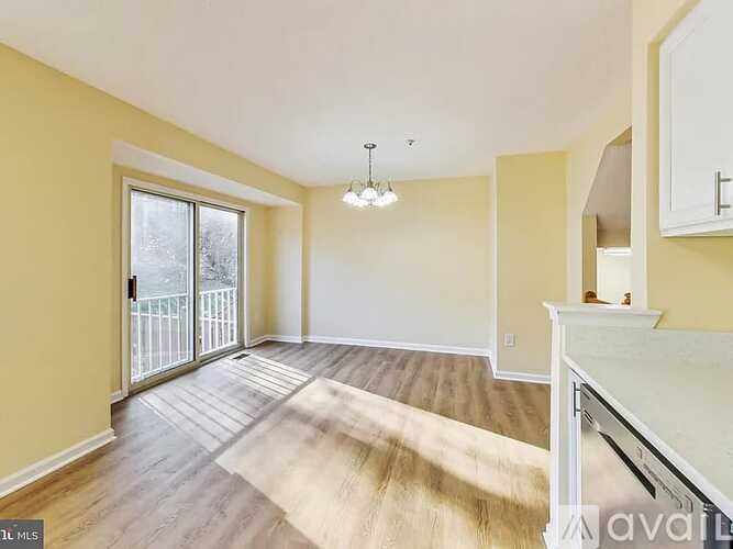 A living room with a white piano and a rug on the floor.