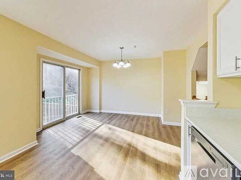 A living room with a white piano and a rug on the floor.